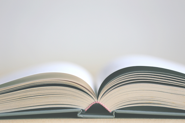 Close-up image of open light blue book on the floor with selective focus and shallow depth of field