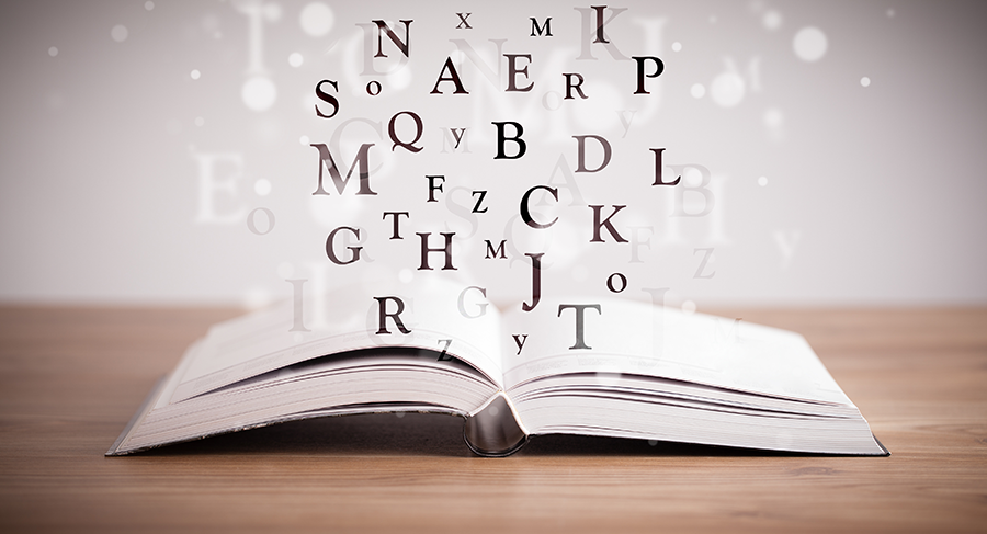 Opened book with flying letters