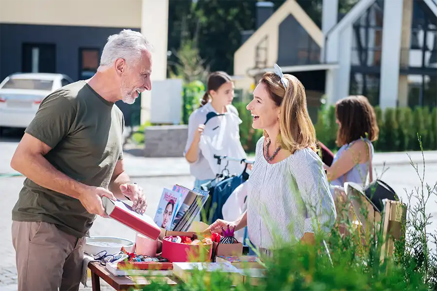 A man and women discussing a book during a small outdoor event