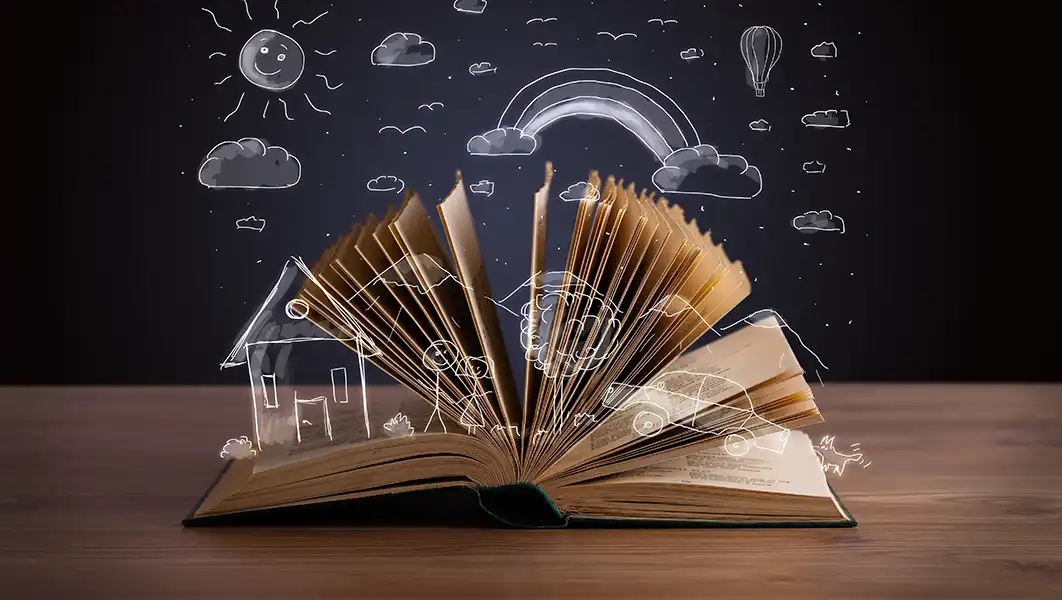 a book opened, resting on a table with white pen drawn animations coming out of it. the animations are a rainbow, clouds, sun